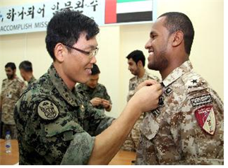 Maj. Park Jin-wu of Korean Akh Unit pins a ceremonial badge of the UAE special forces soldier to mark the first anniversary of the unit’s deployment to the Gulf country. 